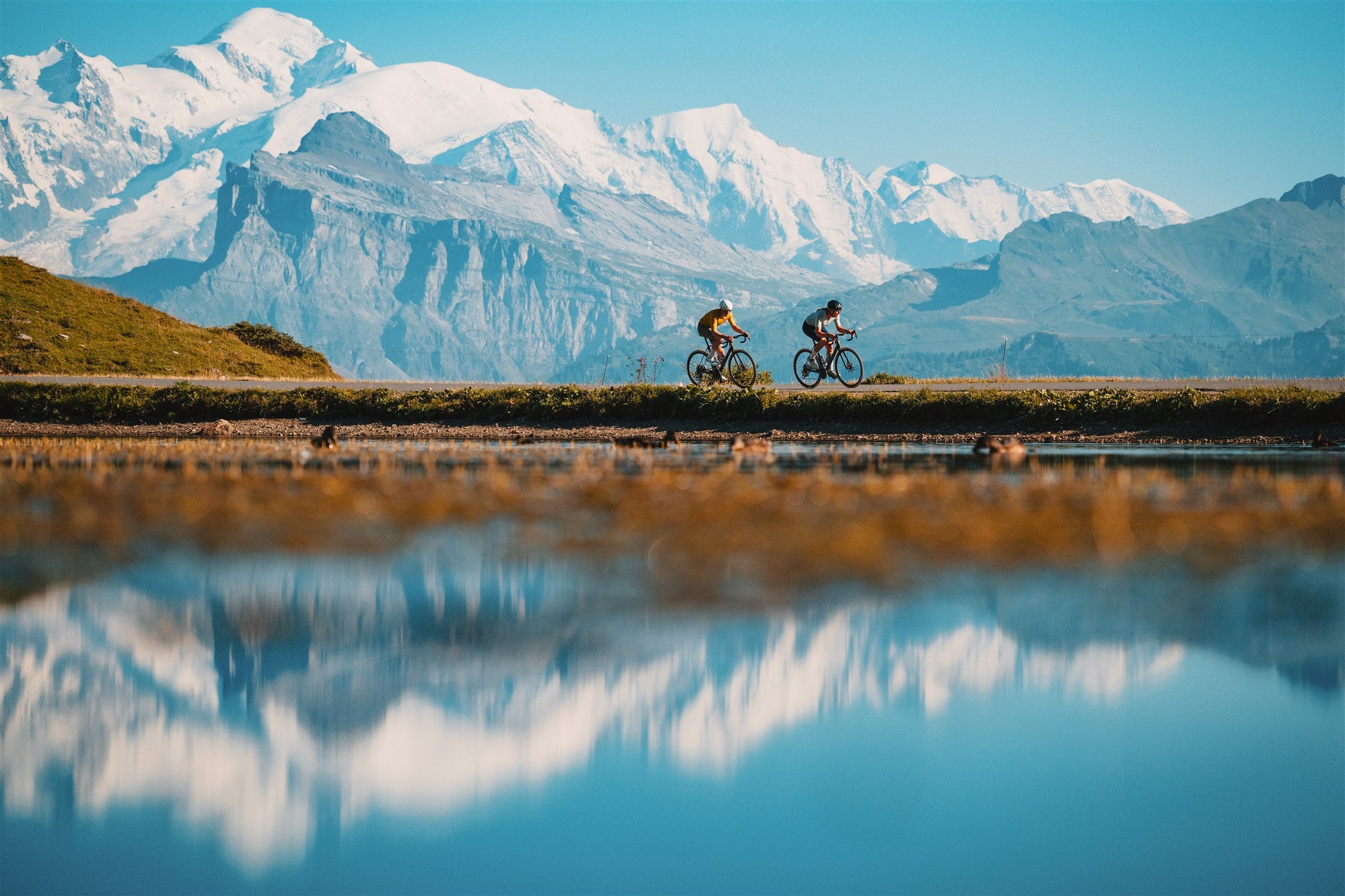 Cyclists riding beside a mountain lake