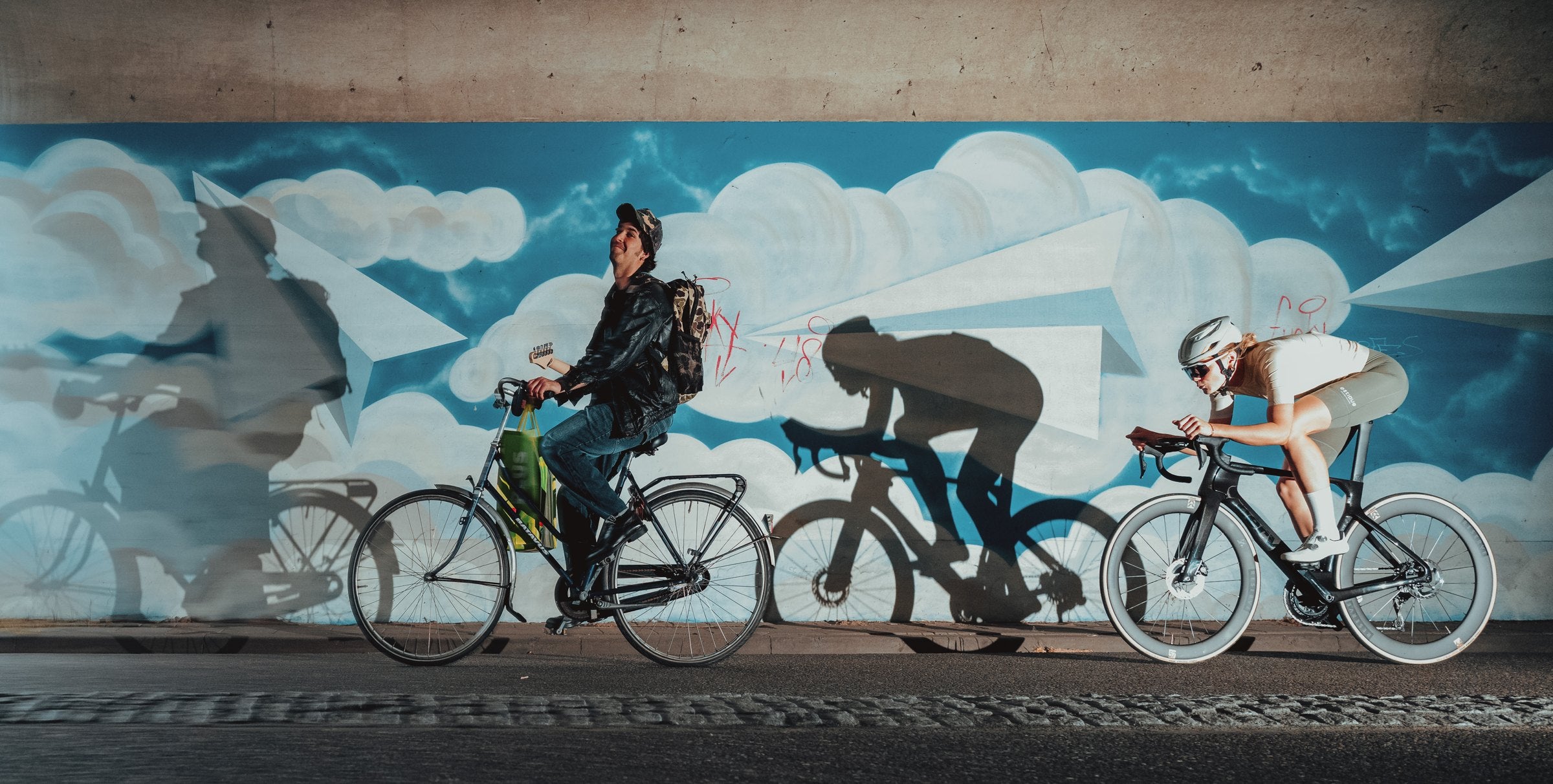 Cyclists riding past a street mural